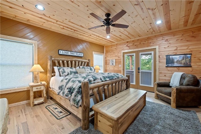 bedroom with wooden ceiling, wood walls, wood finished floors, access to exterior, and french doors