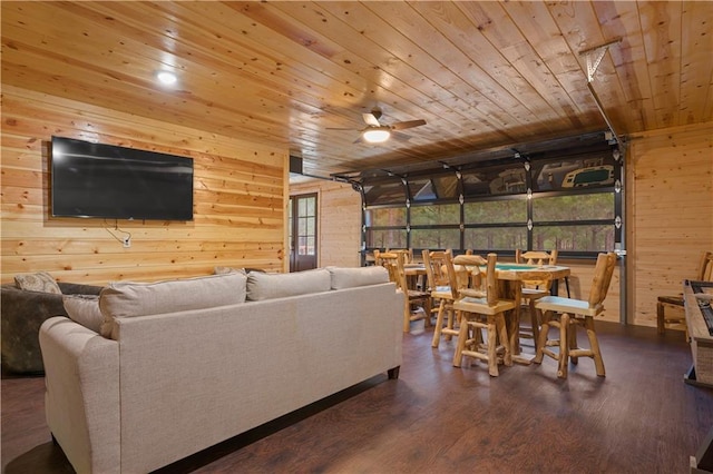 living area with a garage, wood walls, wood ceiling, and wood finished floors