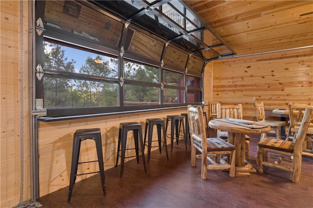 dining area featuring wood finished floors, wood ceiling, and wooden walls