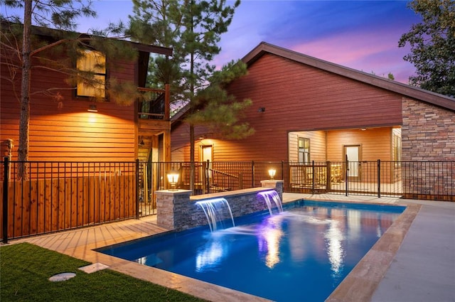 pool at dusk with a fenced in pool