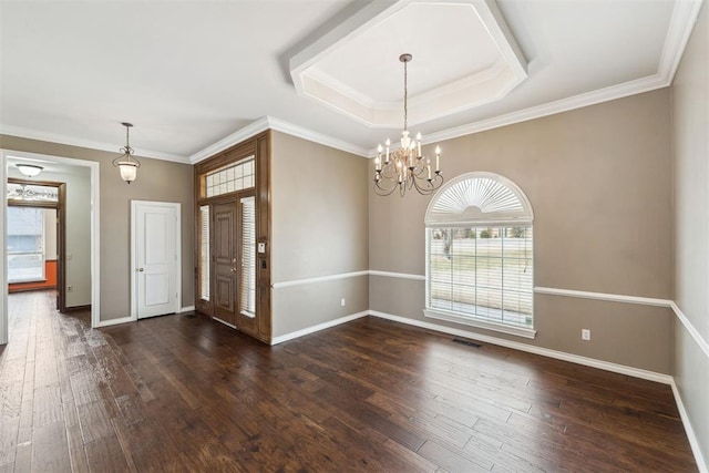 foyer featuring baseboards, dark wood finished floors, crown molding, a raised ceiling, and a notable chandelier