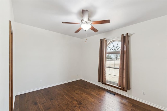 unfurnished room featuring a ceiling fan, baseboards, visible vents, and dark wood-style flooring