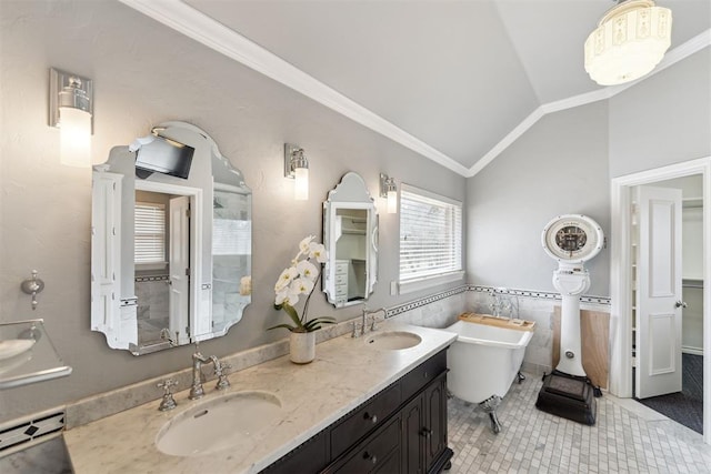 bathroom featuring a sink, a freestanding tub, lofted ceiling, and crown molding