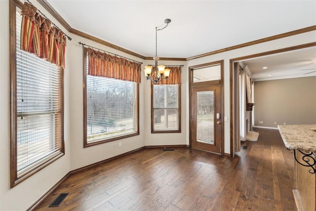 unfurnished dining area with dark wood finished floors, a notable chandelier, crown molding, and visible vents