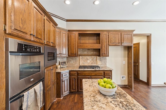 kitchen with light stone counters, backsplash, stainless steel appliances, and dark wood-type flooring