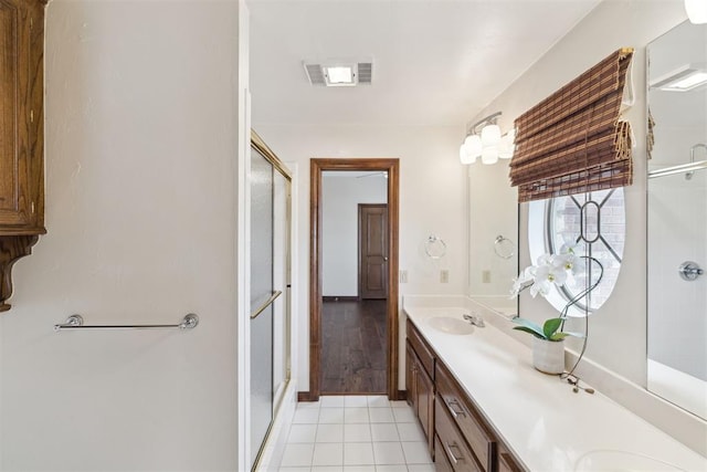 full bath with double vanity, visible vents, a stall shower, and tile patterned flooring