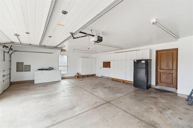 garage featuring electric panel, a garage door opener, and freestanding refrigerator