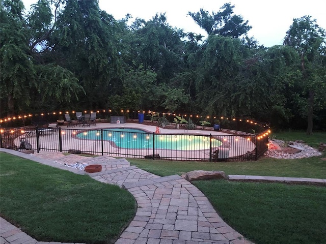 view of swimming pool featuring a patio, a yard, fence, and a fenced in pool