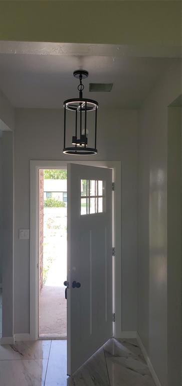 foyer with marble finish floor, visible vents, and baseboards