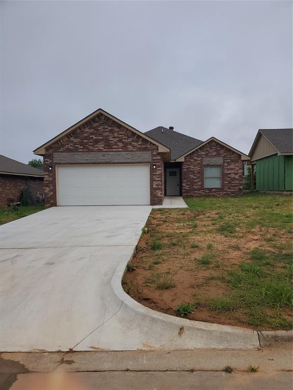 8502 NE 34th Pl, Oklahoma City, OK 73084 - single story home with concrete driveway, a garage, and brick siding