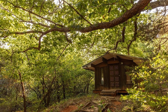 view of outbuilding featuring an outdoor structure and a wooded view