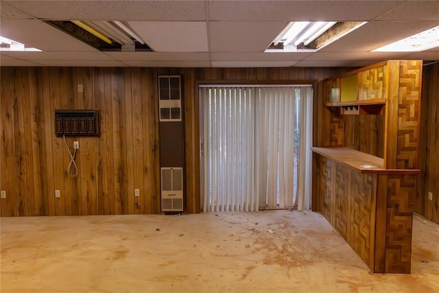 bar featuring a paneled ceiling and wooden walls