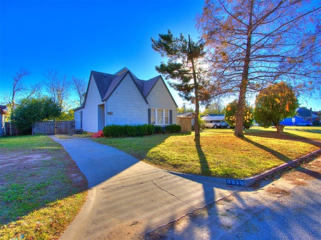 view of home's exterior featuring a lawn and fence