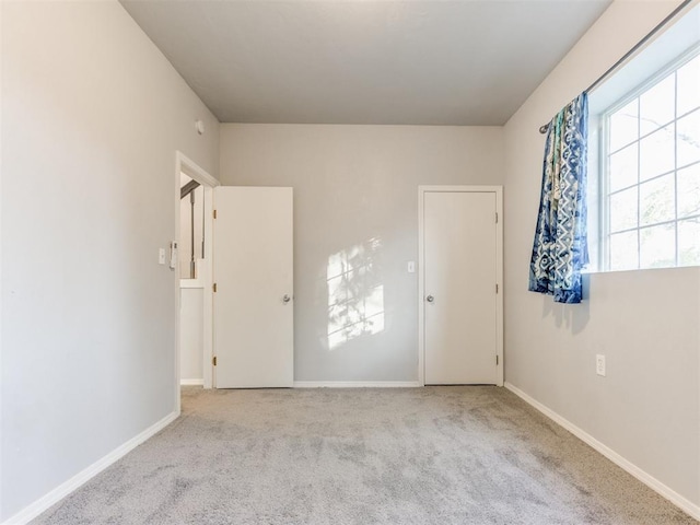 empty room with light colored carpet and baseboards