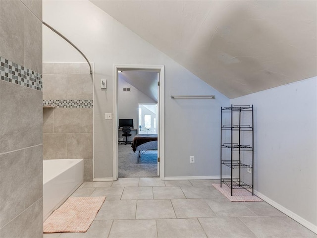 ensuite bathroom with lofted ceiling, tile patterned flooring, connected bathroom, bathing tub / shower combination, and visible vents