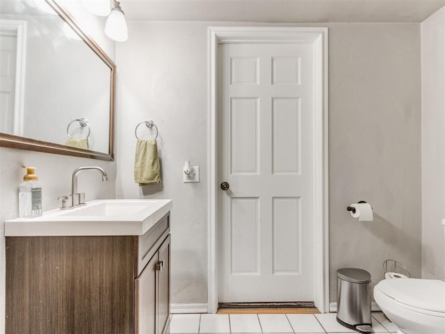 half bathroom featuring toilet, tile patterned floors, and vanity