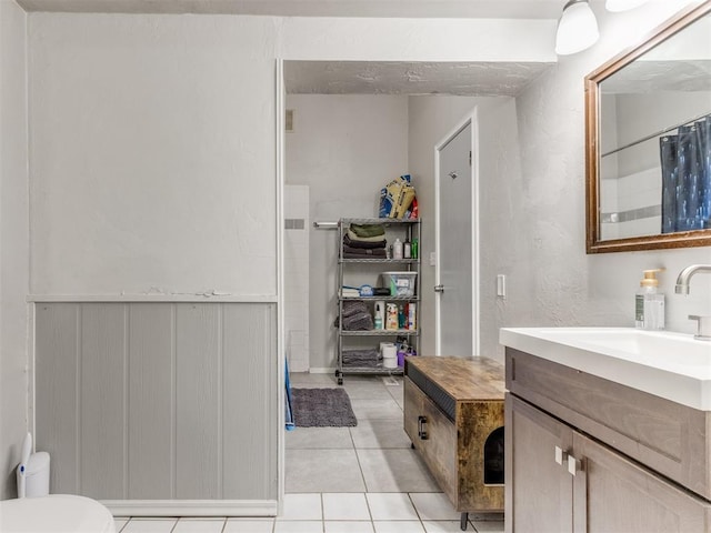 full bath with toilet, tile patterned flooring, and vanity