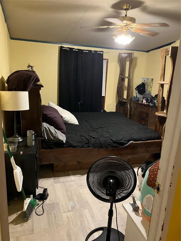 bedroom with light wood-style flooring and a ceiling fan