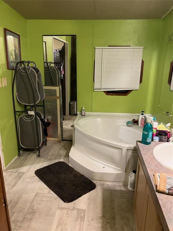 bathroom with a garden tub and vanity