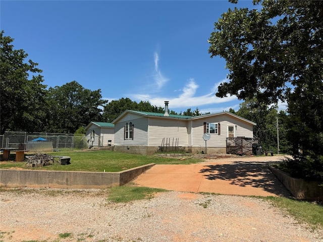 view of front of house with crawl space, driveway, a front lawn, and fence