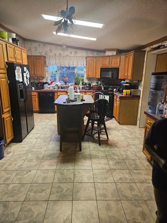 kitchen featuring brown cabinetry, a textured ceiling, black appliances, and wallpapered walls