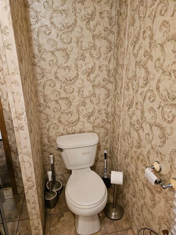 bathroom featuring toilet and tile patterned flooring