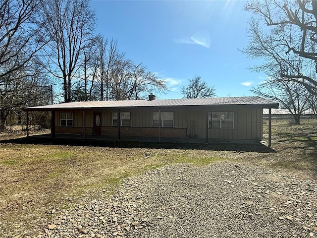 manufactured / mobile home with board and batten siding, a chimney, and a front yard