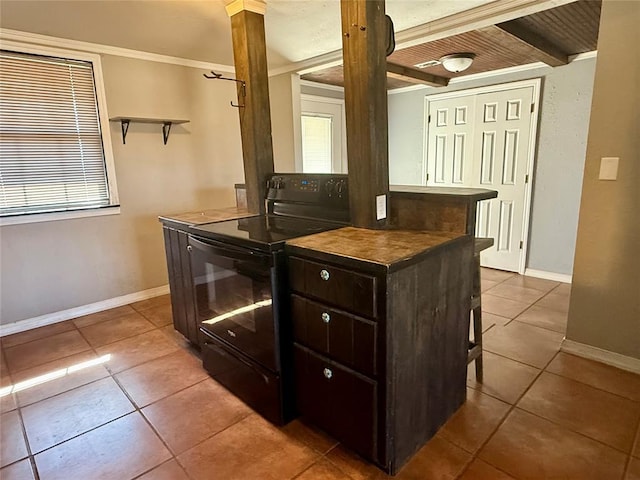 kitchen with dark countertops, black range with electric cooktop, dark brown cabinetry, and light tile patterned floors