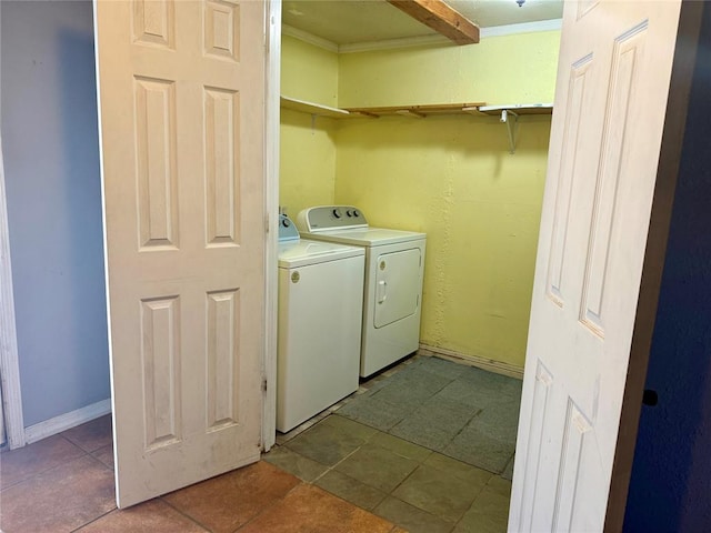 clothes washing area with laundry area, light tile patterned floors, baseboards, and washer and clothes dryer