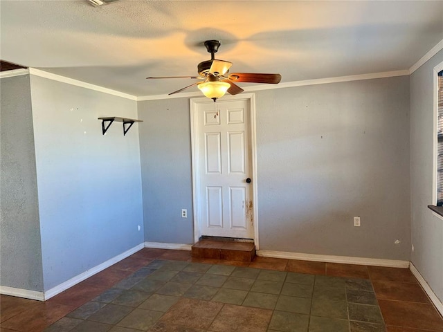 spare room with crown molding, a ceiling fan, and baseboards