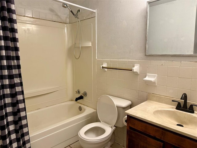 bathroom with a textured wall, toilet, shower / bath combination with curtain, vanity, and tile walls