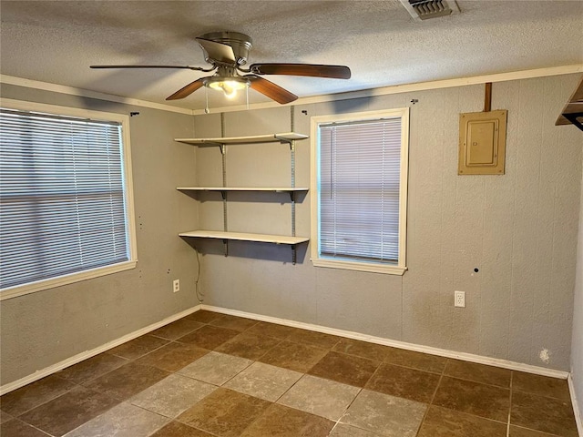 empty room featuring a ceiling fan, electric panel, visible vents, and a textured ceiling