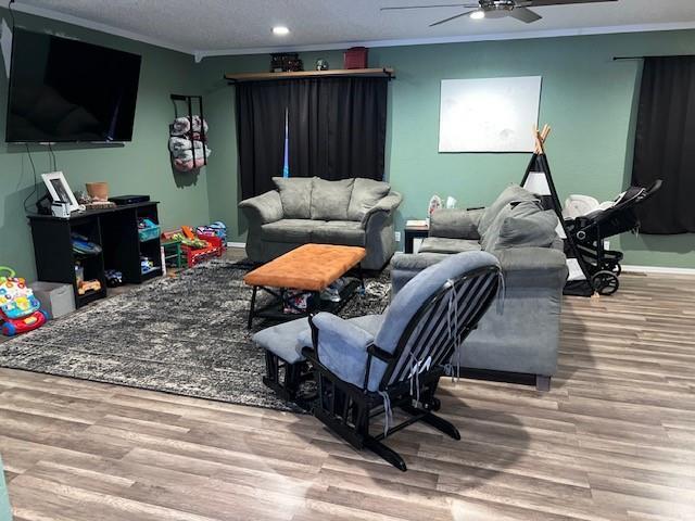 living room with baseboards, ornamental molding, recessed lighting, wood finished floors, and a ceiling fan