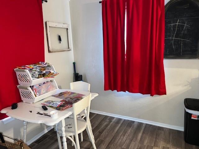 dining area with a barn door, baseboards, and wood finished floors