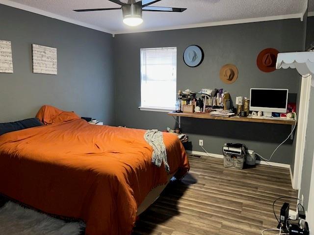 bedroom featuring a textured ceiling, wood finished floors, ceiling fan, and ornamental molding