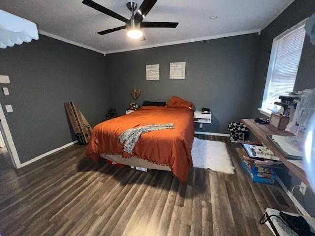 bedroom featuring baseboards, wood finished floors, and ornamental molding