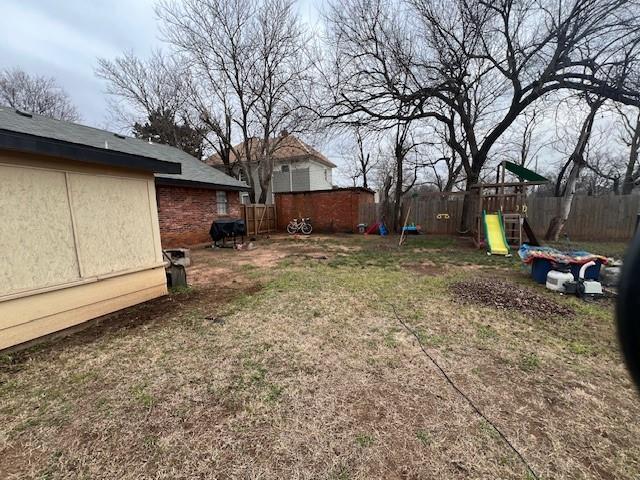 view of yard with a playground and a fenced backyard