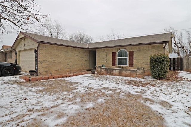 single story home with an attached garage, fence, and brick siding