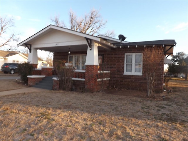 view of front of house featuring covered porch and brick siding