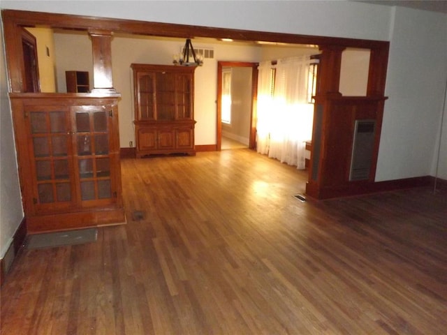 unfurnished living room featuring wood finished floors, visible vents, and baseboards