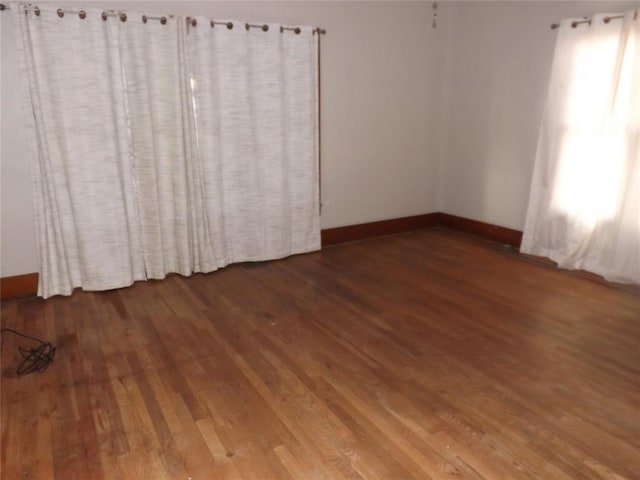 unfurnished room featuring baseboards and wood finished floors