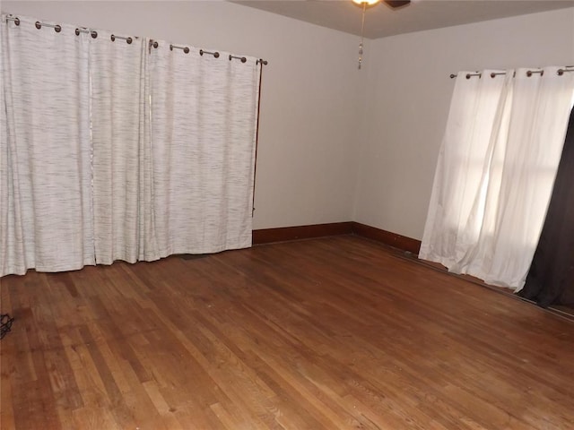 unfurnished room featuring dark wood-style floors and baseboards