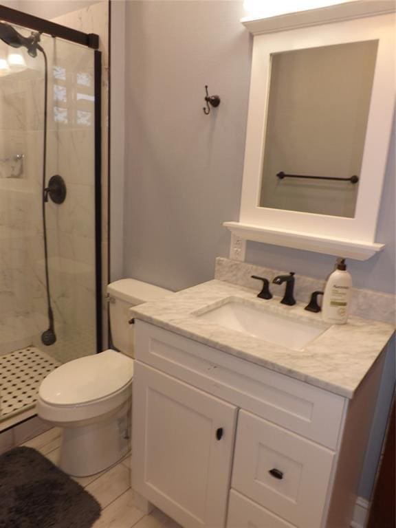 full bathroom with toilet, a shower stall, and vanity