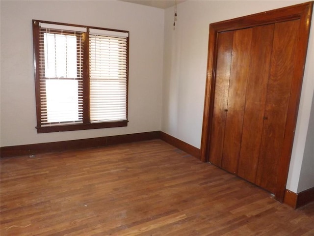 spare room with dark wood finished floors and baseboards