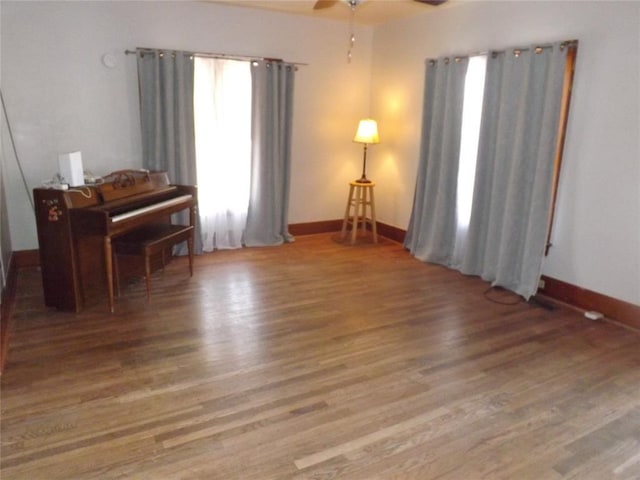 sitting room featuring ceiling fan, baseboards, and wood finished floors