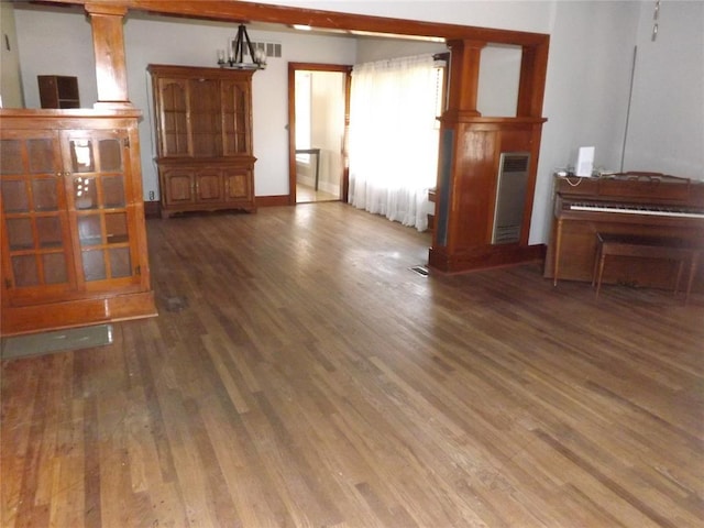 unfurnished living room with wood finished floors and visible vents