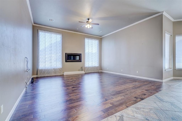 unfurnished living room with a glass covered fireplace, visible vents, crown molding, and wood finished floors