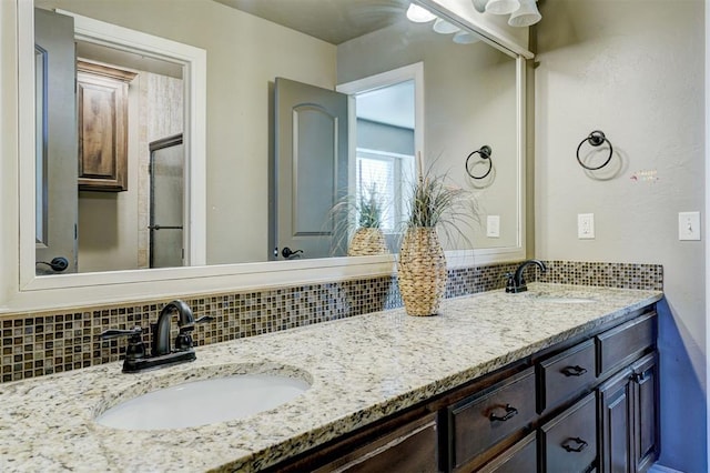 bathroom with double vanity, backsplash, and a sink