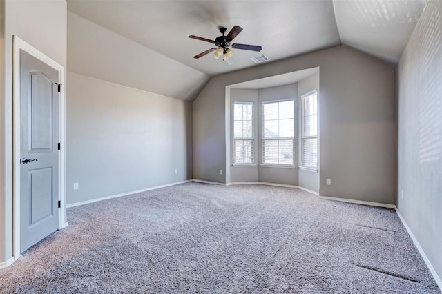 additional living space featuring lofted ceiling, light colored carpet, a ceiling fan, baseboards, and visible vents