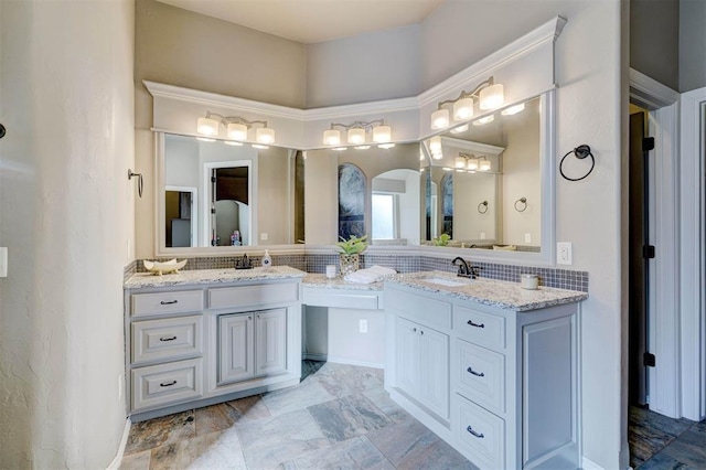 full bath with double vanity, a sink, and decorative backsplash